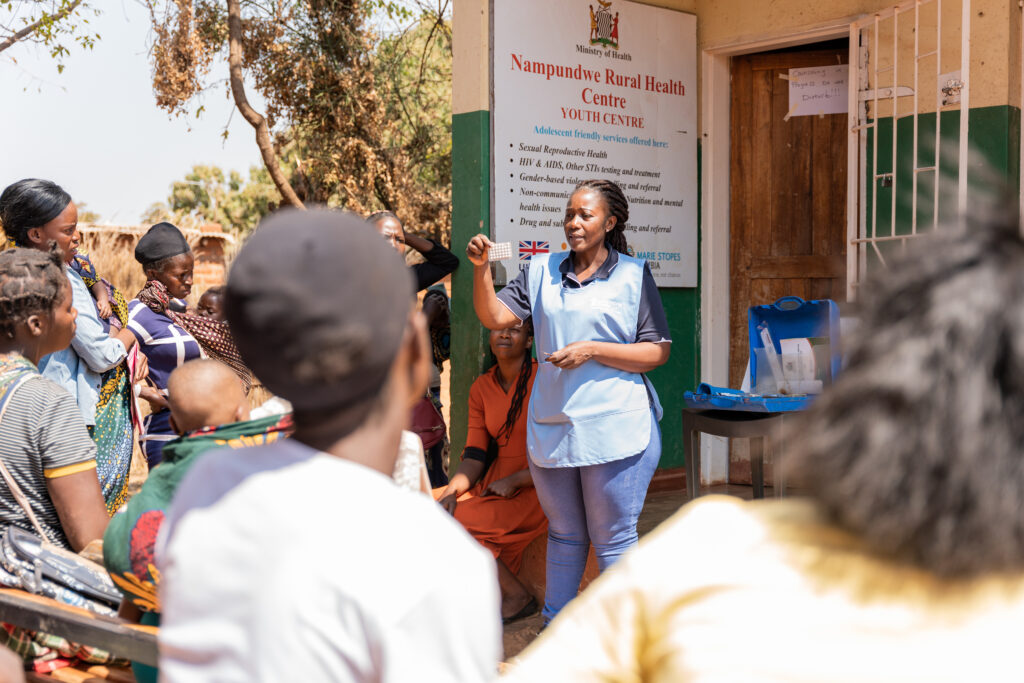 A Service Provider, talks to a group of women at Nampundwe Health Centre.